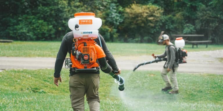 Complete Pest Solutions Employee spraying yard